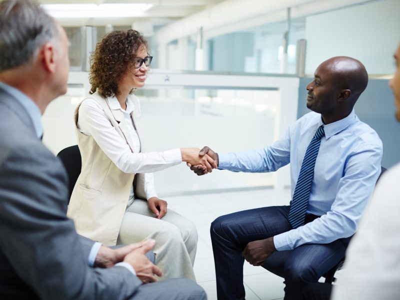 Successful business leaders greeting one another by handshake